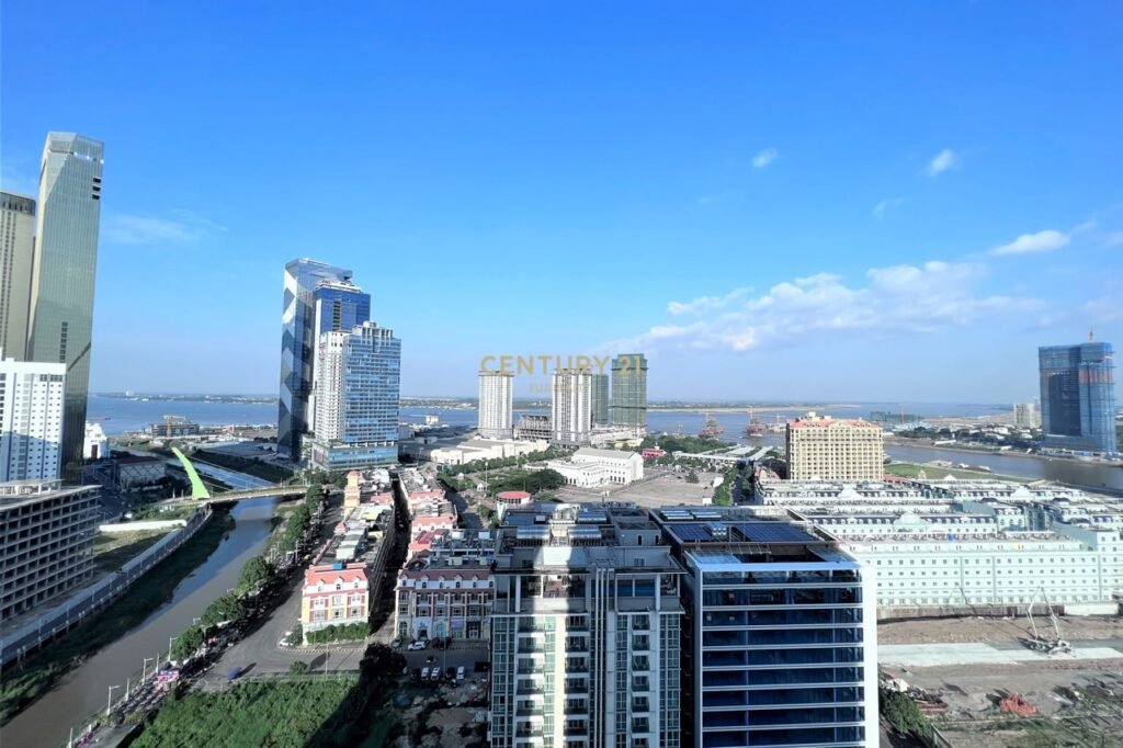 A cityscape with modern high-rises and a river under a clear blue sky. The Century 21 logo is faintly visible in the center, highlighting nearby Apartment 1 Bedroom options amid low-rise buildings and a bridge in the foreground.