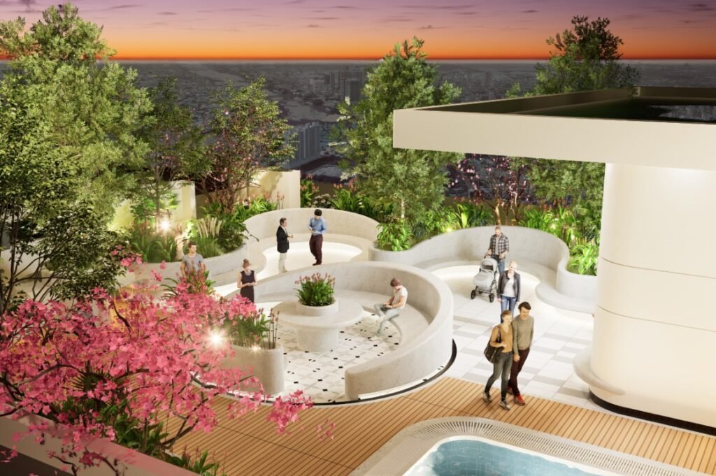 A rooftop garden at sunset with people relaxing, walking, and sitting on curved white benches amid lush greenery and pink flowering trees, overlooking a cityscape in the distance.